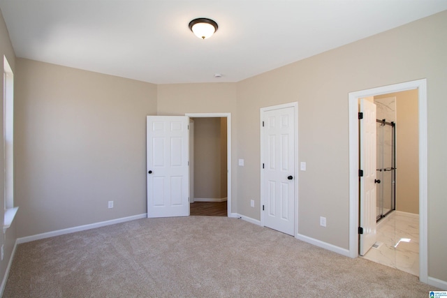 unfurnished bedroom with carpet, ensuite bath, and baseboards