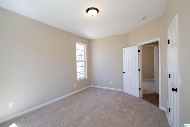 carpeted empty room featuring baseboards