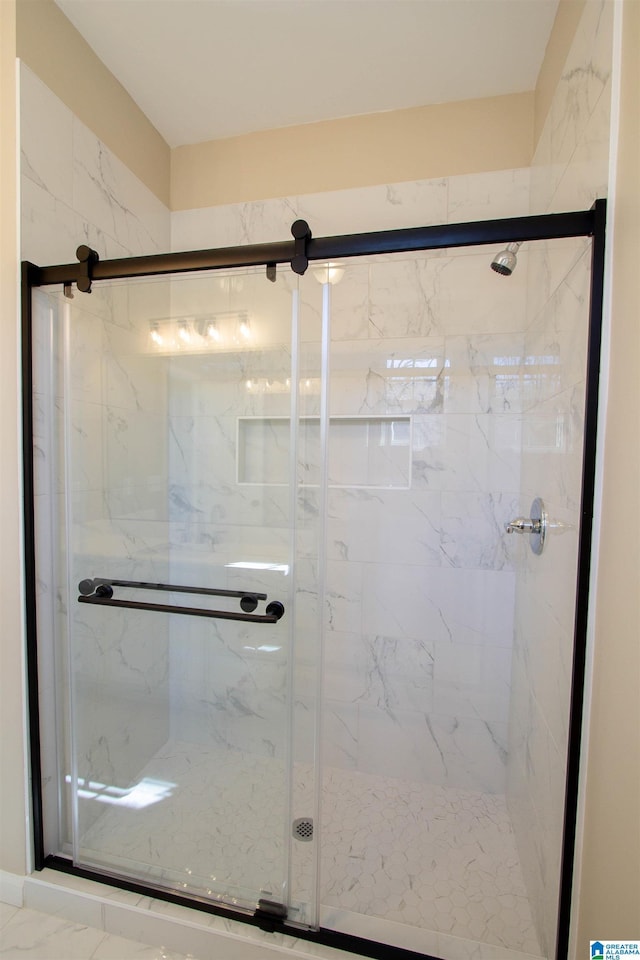 full bath featuring marble finish floor and a stall shower