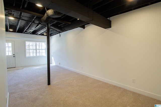 below grade area featuring baseboards and carpet flooring