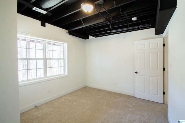 unfurnished room featuring carpet and baseboards