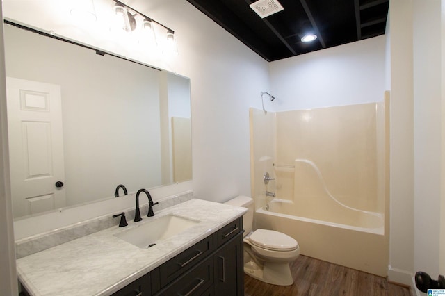 bathroom featuring toilet, shower / bath combination, wood finished floors, vanity, and visible vents