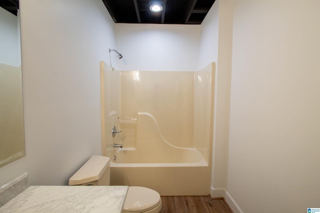 full bath with bathtub / shower combination, toilet, wood finished floors, vanity, and baseboards