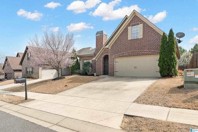 traditional-style home featuring an attached garage, brick siding, driveway, and a chimney