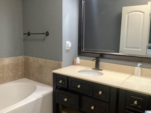 full bath featuring a garden tub and vanity