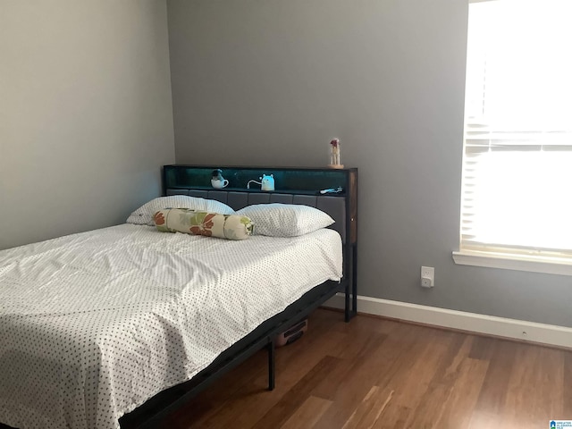 bedroom with baseboards and wood finished floors