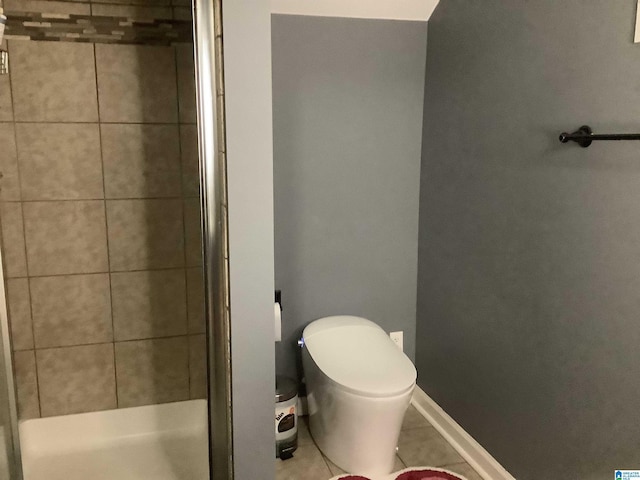 full bath with toilet, a shower stall, baseboards, and tile patterned floors