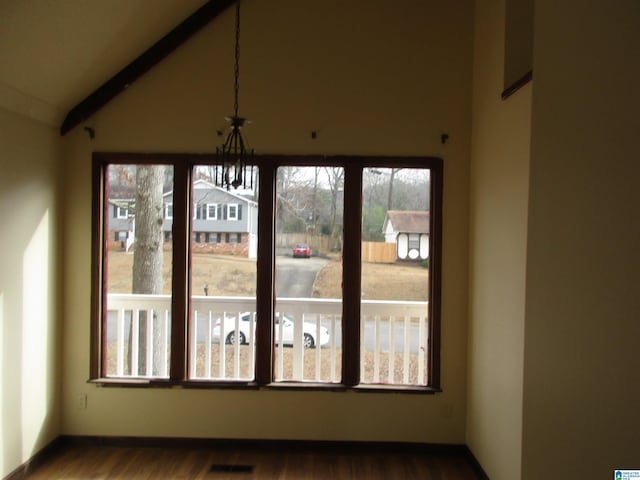 interior space featuring lofted ceiling, visible vents, dark wood finished floors, and baseboards