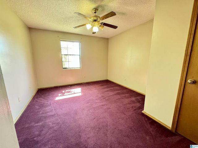 spare room with carpet floors, ceiling fan, a textured ceiling, and baseboards