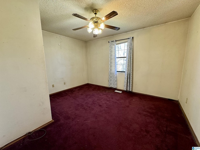 carpeted spare room with visible vents, ceiling fan, a textured ceiling, and baseboards