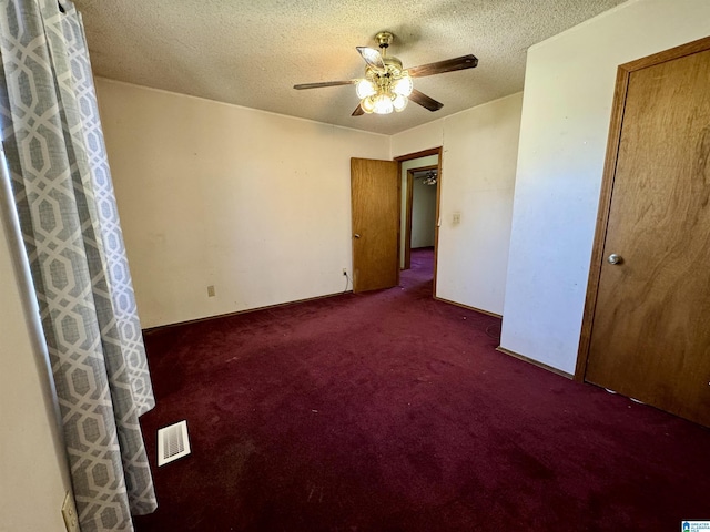 unfurnished bedroom with visible vents, ceiling fan, a textured ceiling, and carpet flooring