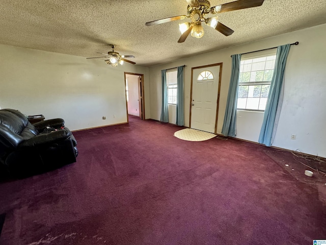 living room featuring a healthy amount of sunlight, a textured ceiling, visible vents, and carpet flooring