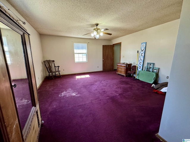 interior space with ceiling fan, a textured ceiling, baseboards, and carpet flooring