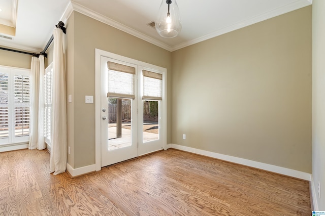 entryway featuring baseboards, light wood-style floors, visible vents, and crown molding