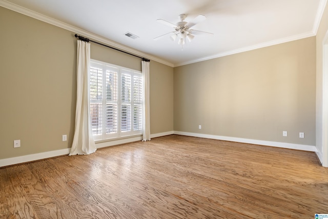 unfurnished room featuring visible vents, wood finished floors, and ornamental molding