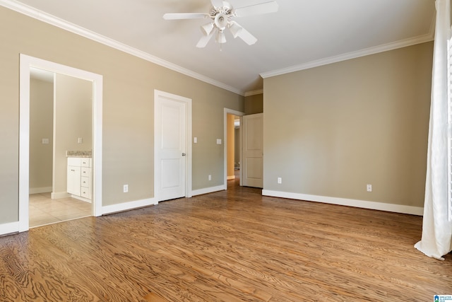 unfurnished bedroom with light wood-style flooring, ornamental molding, baseboards, and ensuite bathroom