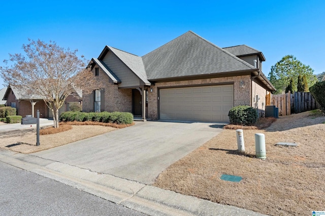 ranch-style home featuring concrete driveway, an attached garage, fence, cooling unit, and brick siding