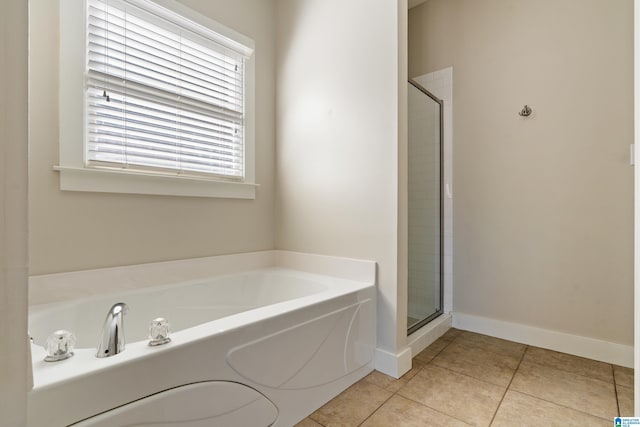 full bathroom featuring a stall shower, tile patterned flooring, baseboards, and a bath