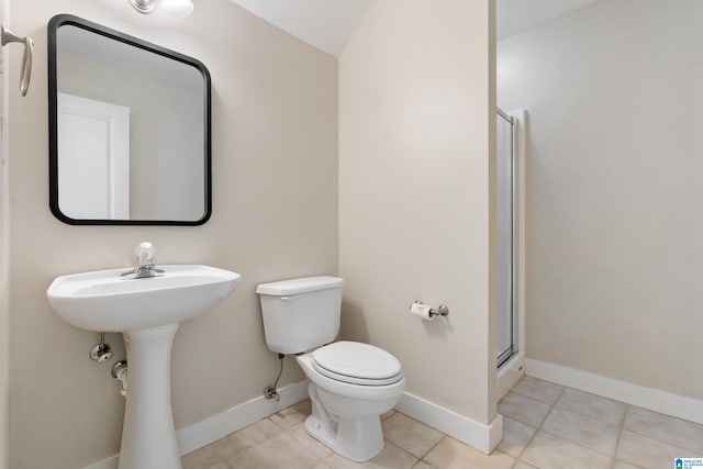 full bathroom featuring toilet, a shower stall, baseboards, and tile patterned floors