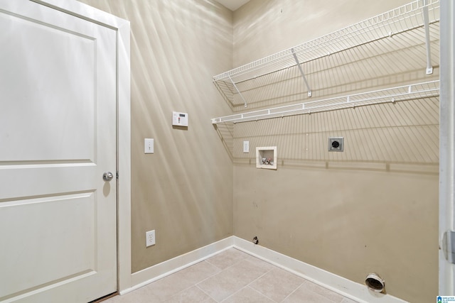 clothes washing area with washer hookup, electric dryer hookup, laundry area, baseboards, and tile patterned floors