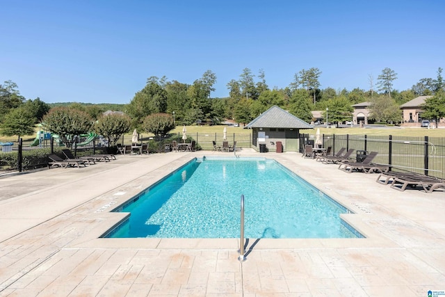 pool with a patio area and fence