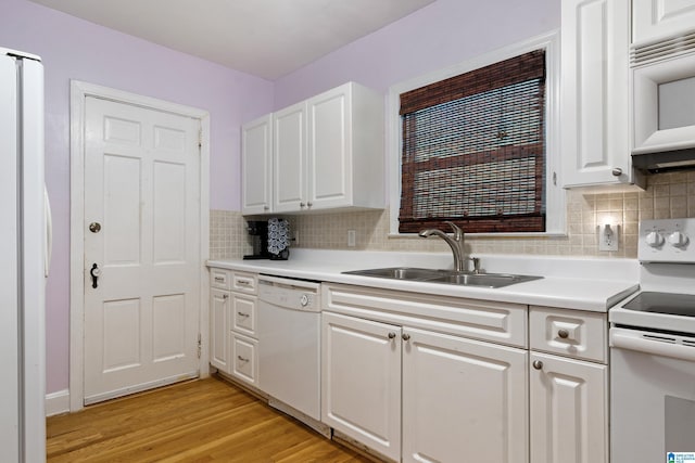 kitchen with white appliances, white cabinets, light wood-style flooring, light countertops, and a sink