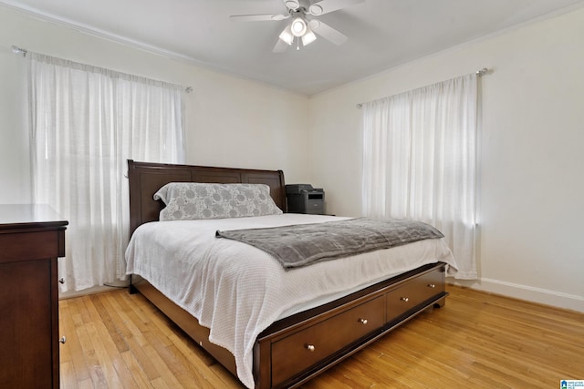 bedroom featuring ceiling fan, light wood-style flooring, and baseboards