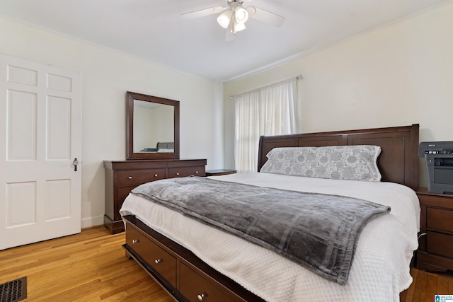 bedroom with visible vents, baseboards, light wood-style flooring, and a ceiling fan