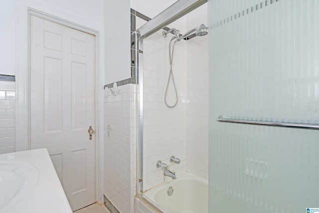 bathroom with enclosed tub / shower combo and a sink