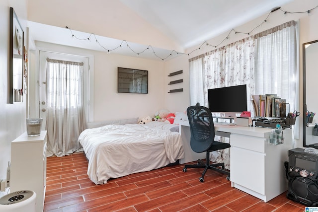 bedroom with vaulted ceiling and wood tiled floor