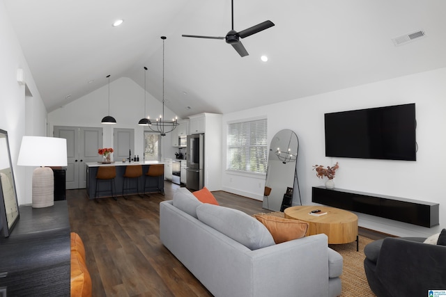 living area with visible vents, dark wood finished floors, ceiling fan with notable chandelier, high vaulted ceiling, and recessed lighting