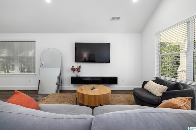 living area with visible vents, vaulted ceiling, baseboards, and wood finished floors