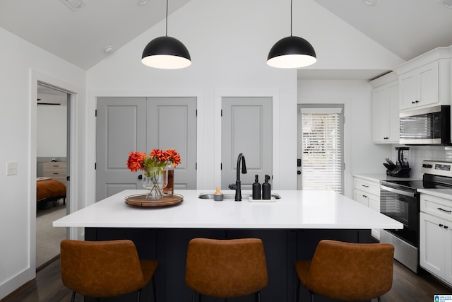 kitchen featuring appliances with stainless steel finishes, a sink, and a kitchen breakfast bar