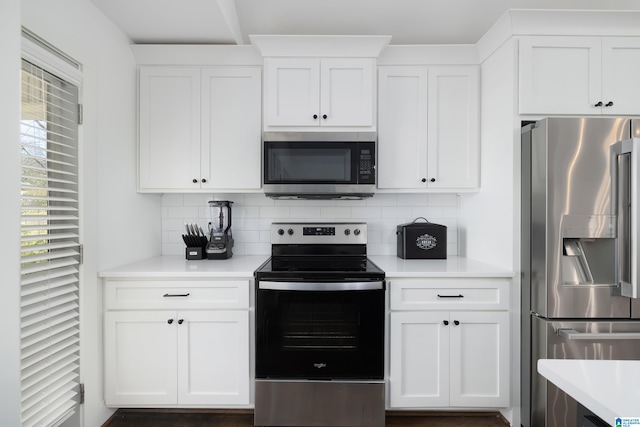 kitchen featuring appliances with stainless steel finishes, white cabinets, light countertops, and decorative backsplash