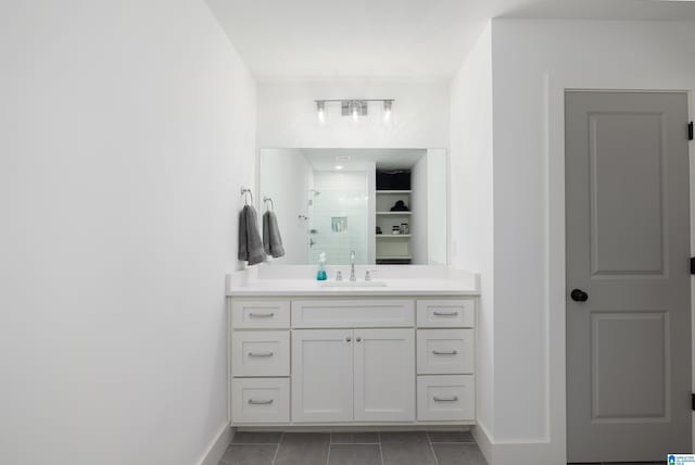 full bath featuring baseboards, a shower stall, vanity, and tile patterned floors