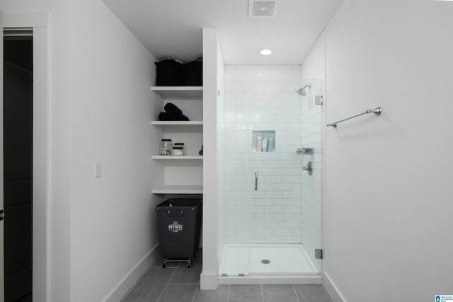 bathroom featuring tile patterned flooring, a shower stall, visible vents, and baseboards