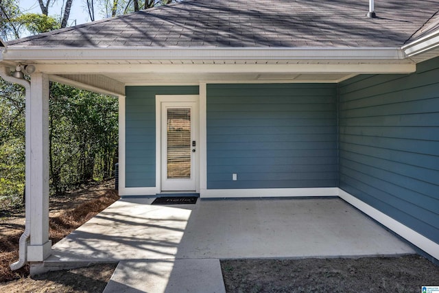 entrance to property featuring a shingled roof