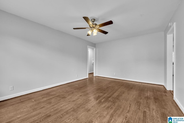 spare room featuring ceiling fan, baseboards, and wood finished floors