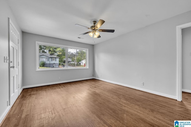 unfurnished bedroom with visible vents, ceiling fan, baseboards, and wood finished floors