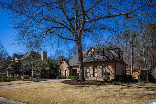 view of front facade with a front lawn and brick siding