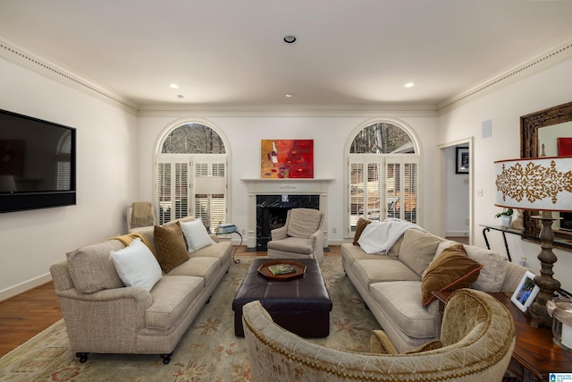 living room with crown molding, baseboards, wood finished floors, and a high end fireplace