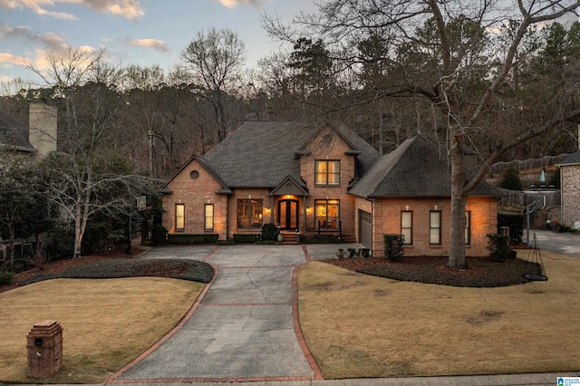 view of front of house with concrete driveway, brick siding, a shingled roof, and a front yard