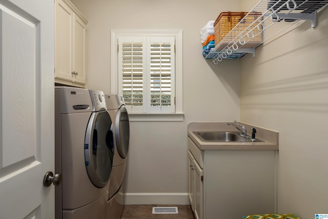 laundry area with cabinet space, visible vents, baseboards, washer and dryer, and a sink