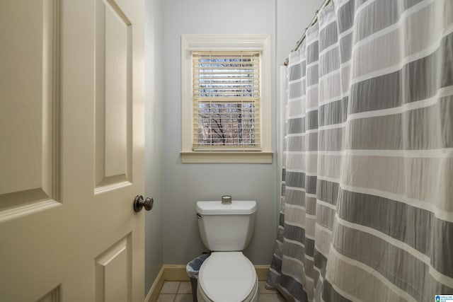 bathroom with a shower with curtain, baseboards, toilet, and tile patterned floors