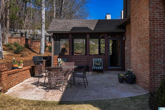 view of patio featuring outdoor dining area, a sunroom, fence, and grilling area