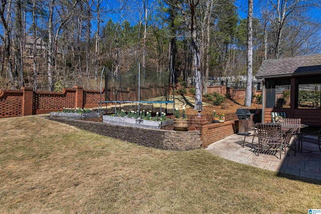 view of yard with a trampoline, a patio area, and fence