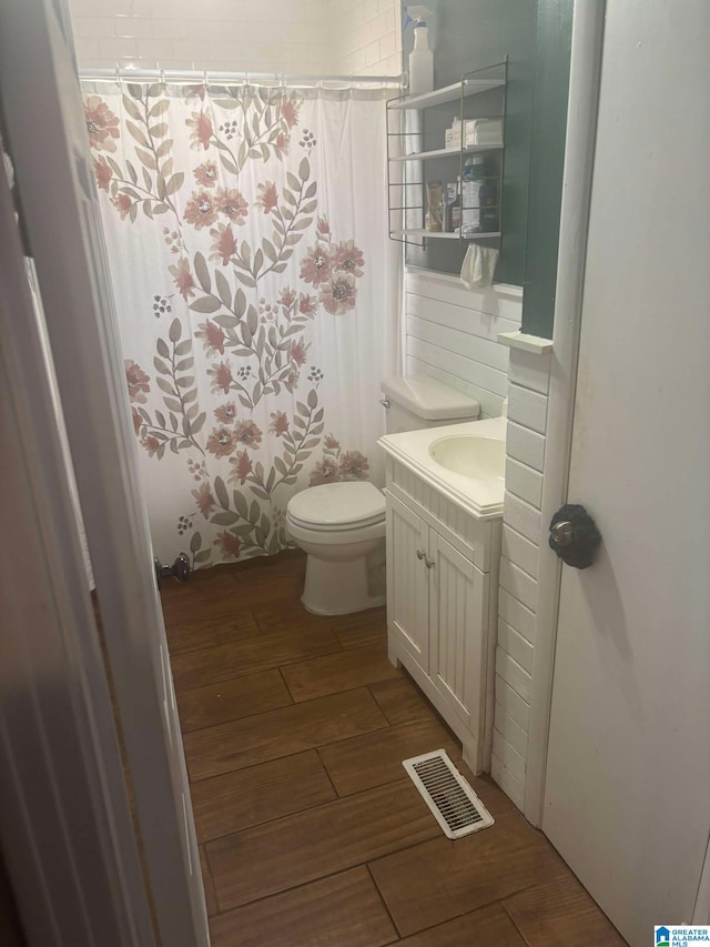 full bath with toilet, wood finish floors, vanity, visible vents, and a shower with curtain