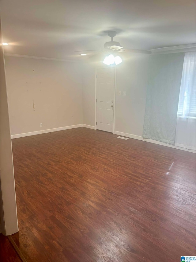 spare room featuring dark wood-style floors, ceiling fan, and baseboards