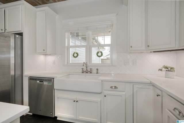 kitchen featuring appliances with stainless steel finishes, white cabinets, a sink, and light countertops