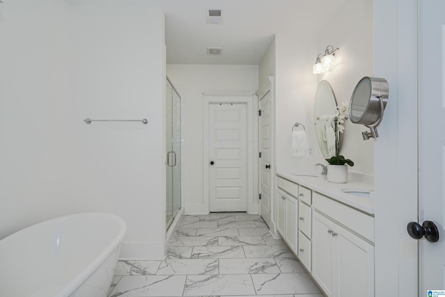 full bathroom featuring a sink, a freestanding bath, marble finish floor, a shower stall, and double vanity